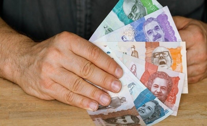 Colombia currency, a man holds a fan of money in his hand, Business and financial concept